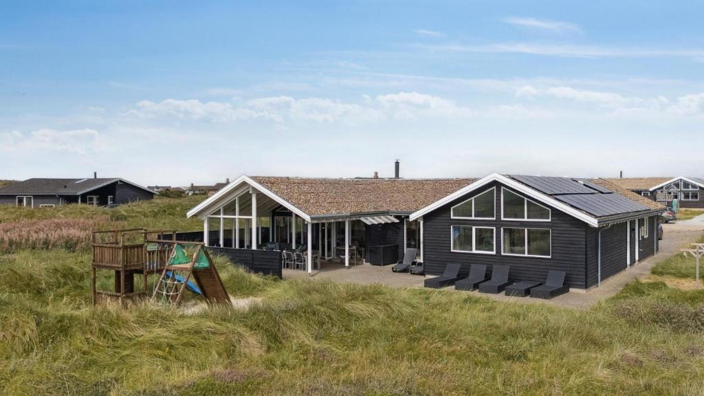 una casa nera in un campo erboso di Villavilla #292 - Søndervig, Vestjylland a Klegod