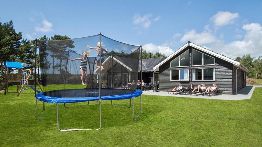 eine Gruppe von Menschen, die auf einem Trampolin in einem Hof spielen in der Unterkunft Villavilla #347 - Dueodde, Bornholm in Bedegård
