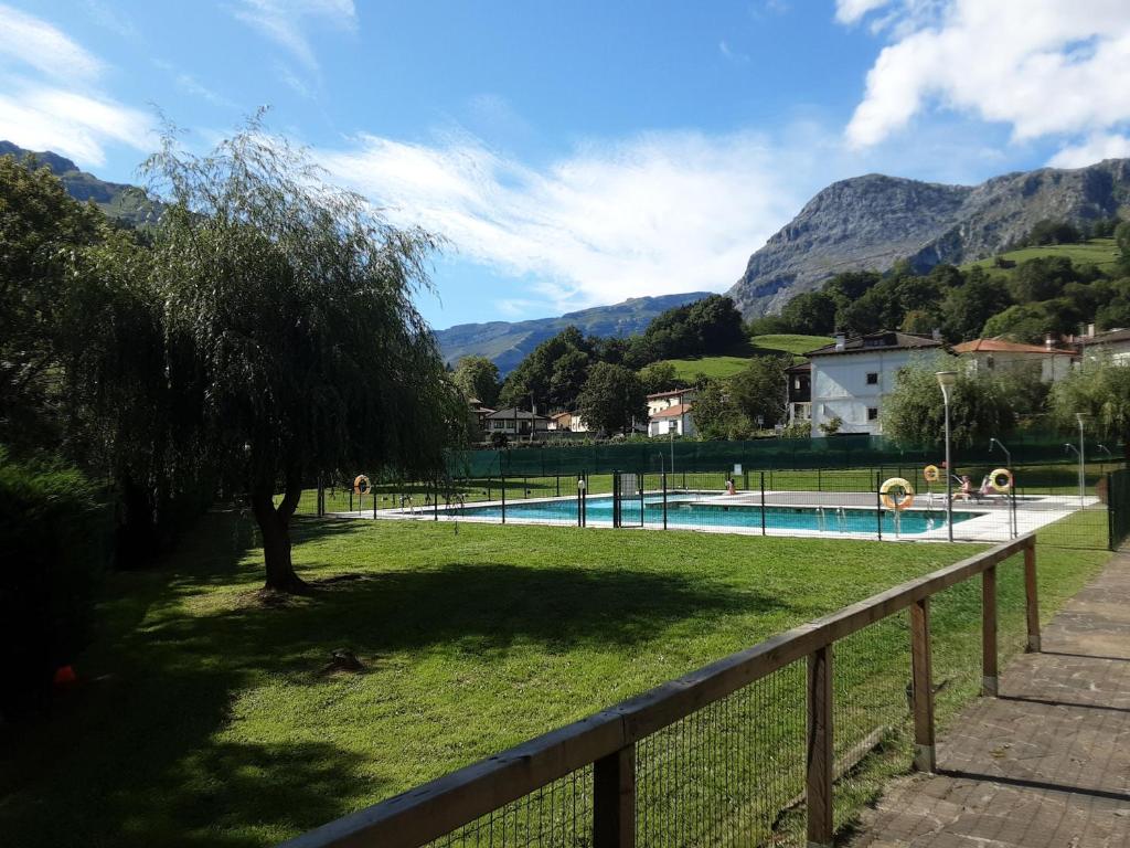 a swimming pool in a park with mountains in the background at Entrecuevas - Rural Accommodation in Arredondo