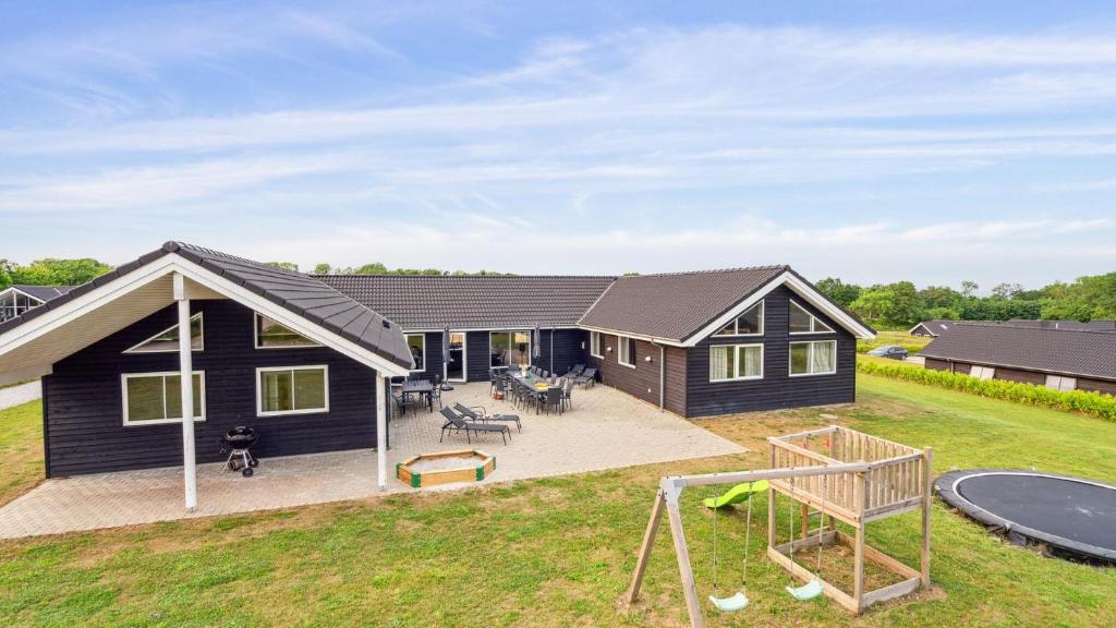 een huis met een speeltuin en een huis bij Villavilla #508 - Mommark, Sydjylland in Sarup