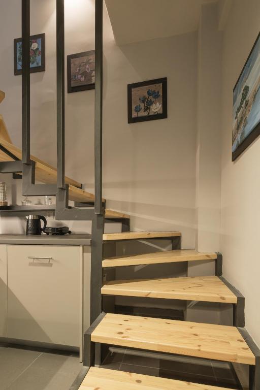 a kitchen with wooden stairs in a room at Annita's Cozy Loft Volos in Volos
