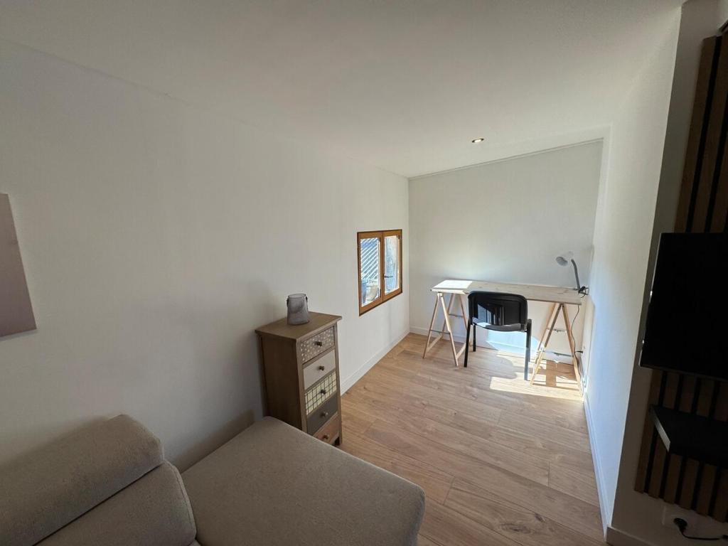 un salon avec un canapé et un bureau dans l'établissement L'élégante, à Saint-Trivier-de-Courtes