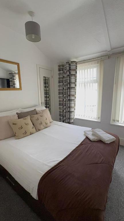 een groot wit bed in een kamer met ramen bij No 34 Vance Road in Blackpool