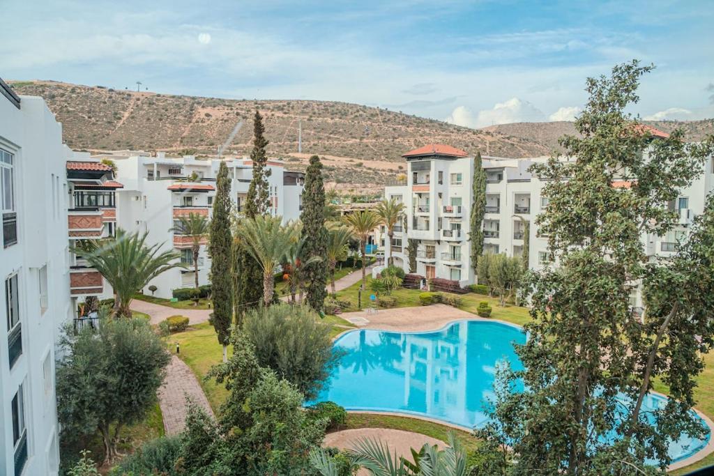 an apartment building with a swimming pool and trees at Marina Agadir Grand Luxury 3 Bedroom Sea view Apartment-familial in Agadir