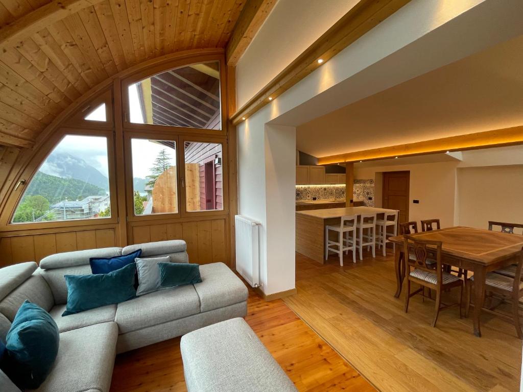 een woonkamer met een bank en een tafel bij Luna Rossa Dolomiti in Domegge di Cadore