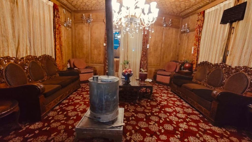a large living room with couches and a chandelier at Heritage Houseboat - Almost Heaven in Srinagar