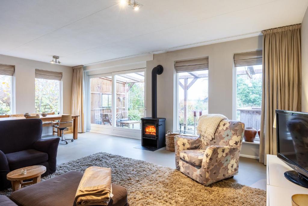 een woonkamer met een stoel en een open haard bij Appartementen Ossegang in Uithuizen