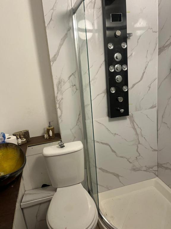 a bathroom with a toilet and a glass shower at Premiership Lodge in Beeston Hill