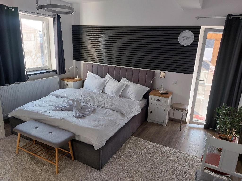 a bedroom with a bed and a clock on the wall at Casa Capibarei 3 in Bragadiru