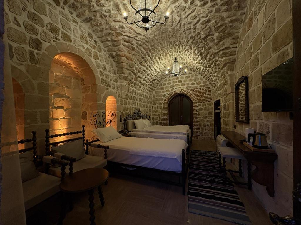una camera con due letti in un muro di mattoni di Arami Han Konağı a Mardin