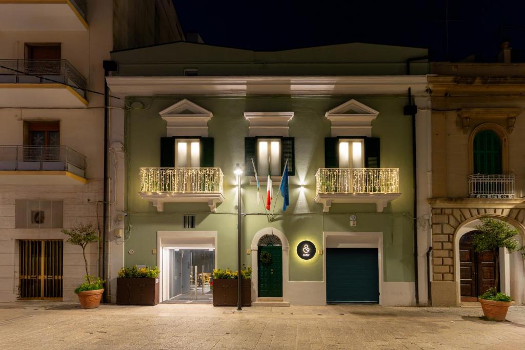 a green building with two balconies and a flag at CA' DO' Guest House in Matera