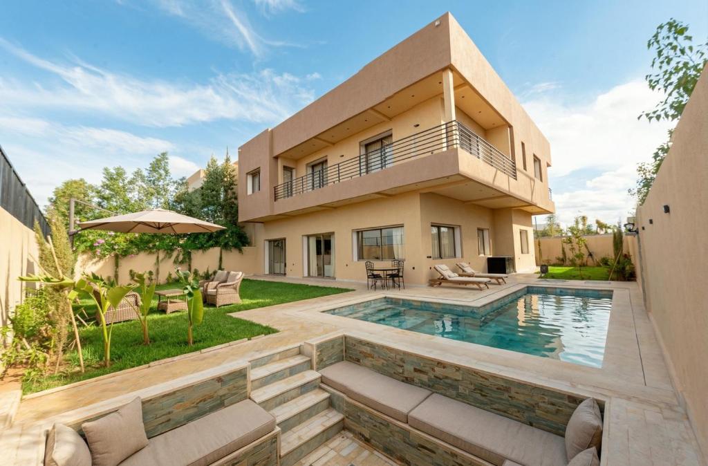 a home with a swimming pool and a house at Villa Soliya 4 Rooms with private pool in Marrakesh
