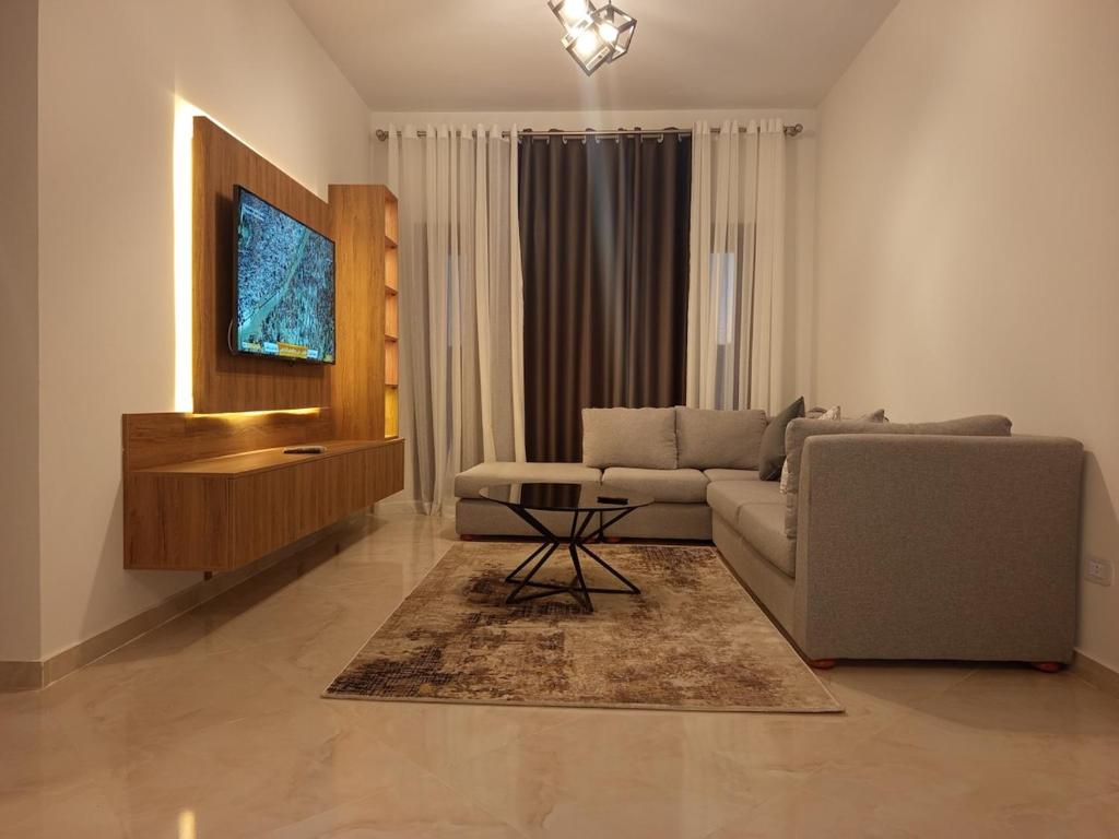 een woonkamer met een bank en een tv bij Golf Heights Resort Nabk Bay Sharm El Sheikh One Bedroom Apartment in Sharm El Sheikh