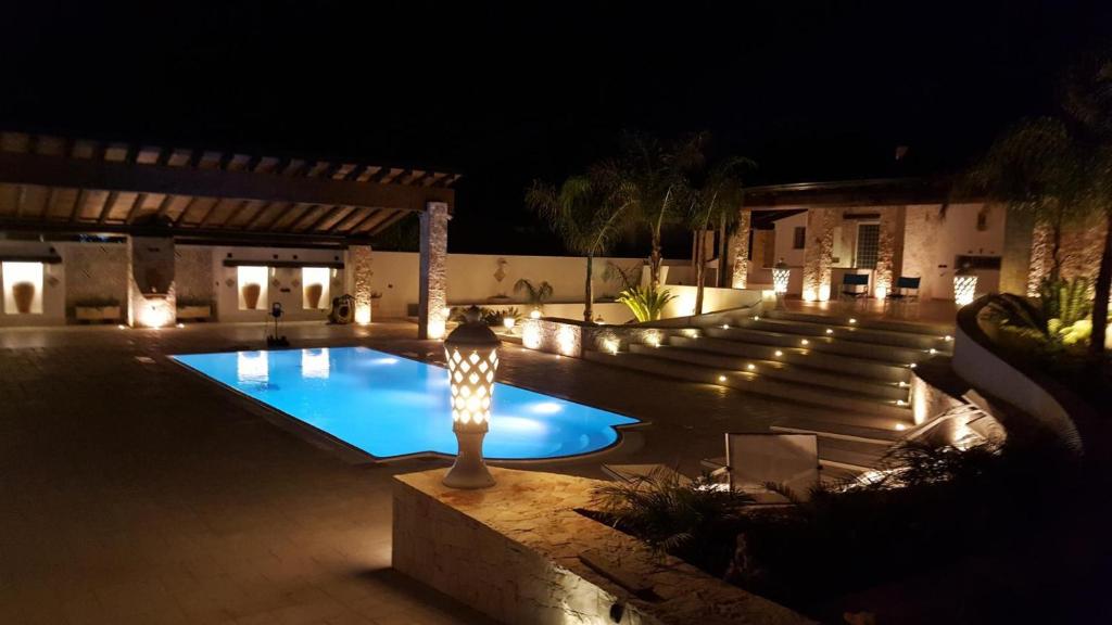 een zwembad 's nachts met een licht in het midden bij Villa Nazarena in Torre Suda