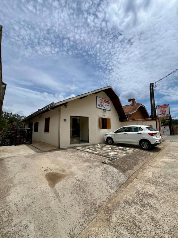 a car parked in a parking lot in front of a building at Casa Moreira´s Chalés in Monte Verde