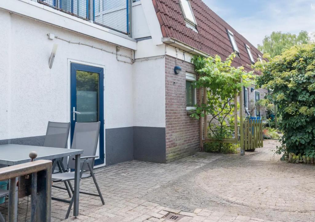 eine Terrasse mit einem Tisch und Stühlen neben einem Gebäude in der Unterkunft Vakantiewoning Afterdaan in Elim