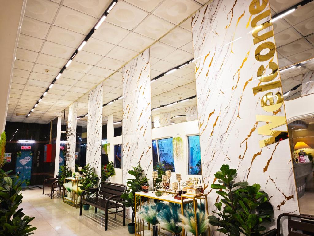 a lobby with tables and chairs and plants at Hotel Ma'Wa Kota Bharu in Kota Bharu