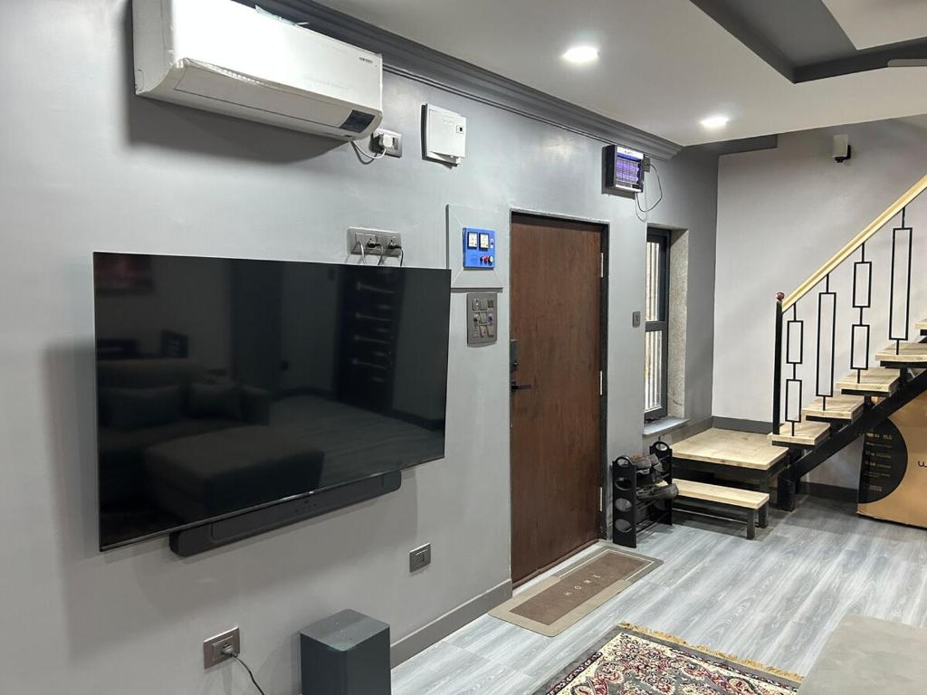 Zimmer mit einem großen Flachbild-TV an der Wand in der Unterkunft Barkat Manzil in Bharūch