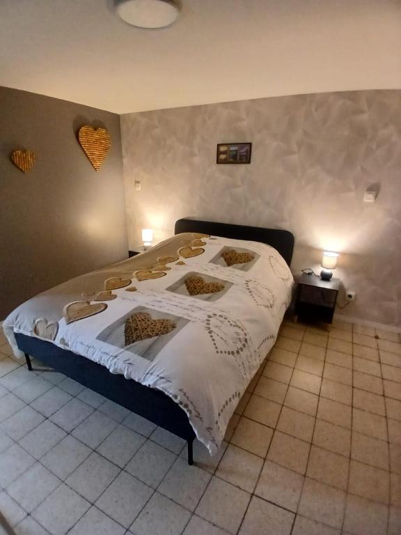 a bedroom with a large bed with white sheets at li ptit coeur in Hastière-Lavaux