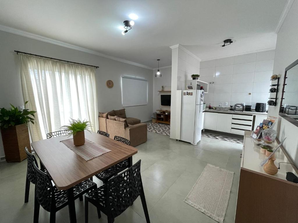 Il dispose d'une cuisine et d'un salon avec une table et des chaises en bois. dans l'établissement Casa Lago da Dinda 3, à Espirito Santo Do Pinhal