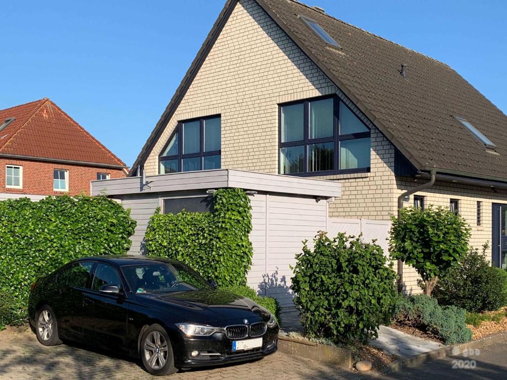 ein schwarzes Auto, das vor einem Haus geparkt ist in der Unterkunft Willkommen-Glückstadt in Glückstadt