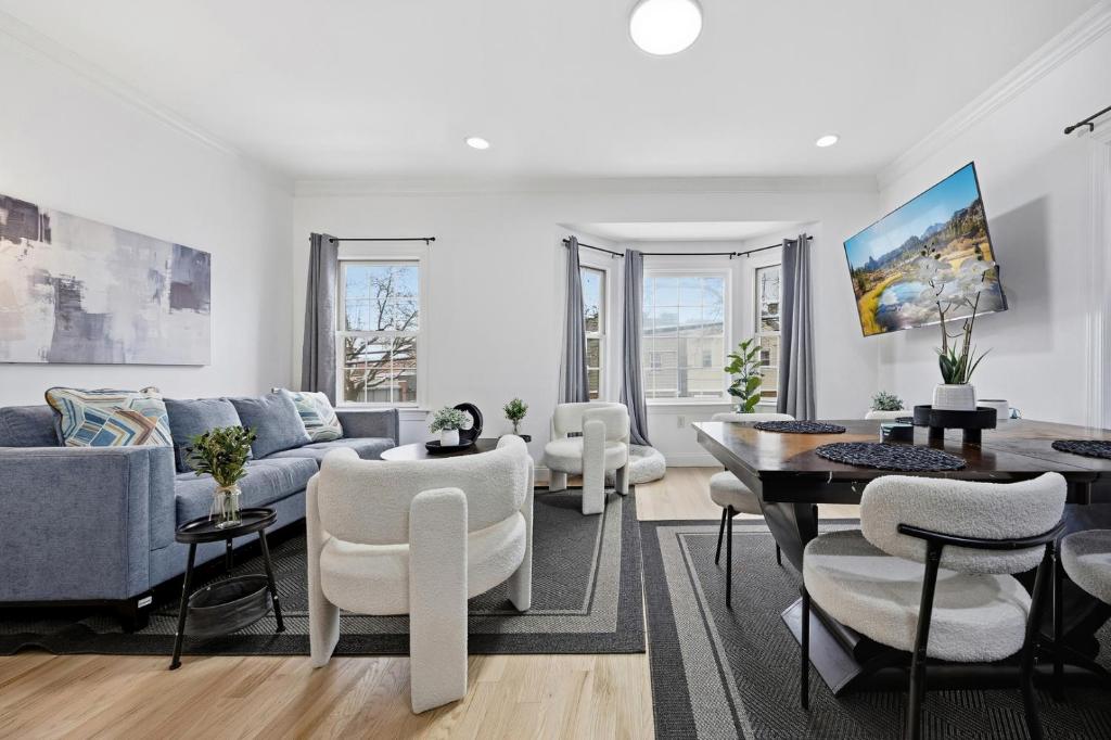 a living room with a couch and a table and chairs at Sleeps 18! - 6 BR - 2 Kitchens in Jersey City