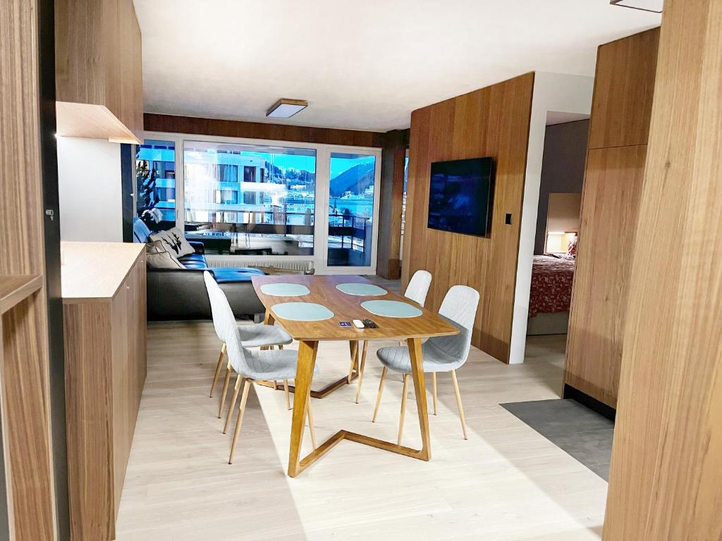 een keuken en eetkamer met een houten tafel en stoelen bij Mountain Loft - DuLac 33 in St. Moritz