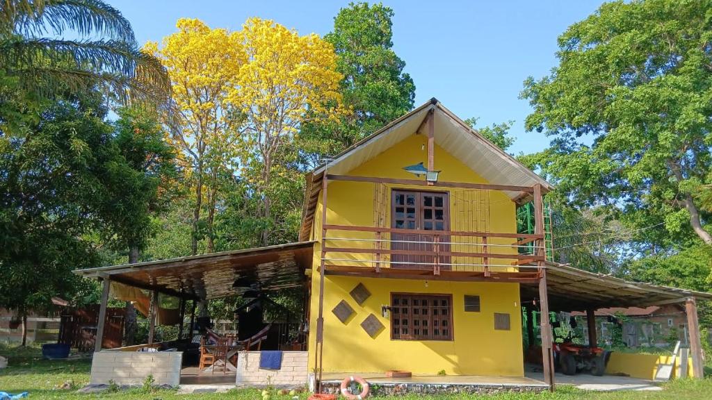a yellow house with a gambrel roof at Chalé Gran Paraíso Cotijuba in Belém