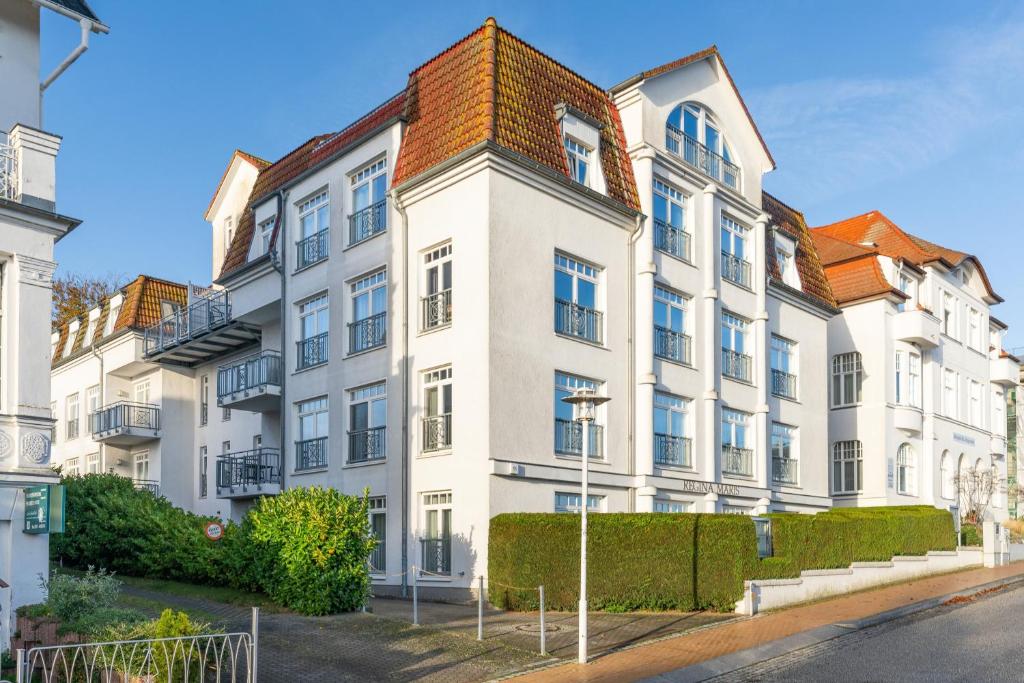 ein großes weißes Gebäude mit rotem Dach in der Unterkunft Ferienwohnungen Regina Maris in Bansin