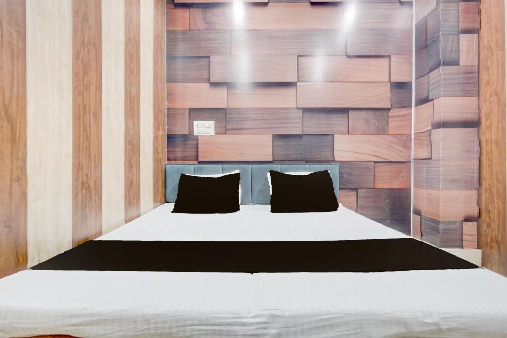una camera da letto con un letto con una parete in legno di SPOT ON The Yeble Hotel And Restaurant a Etāwah