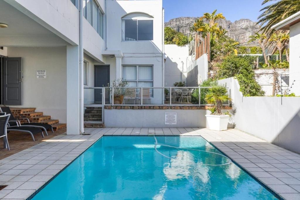 a swimming pool in front of a house at Luxury Camps Bay Getaway in Cape Town
