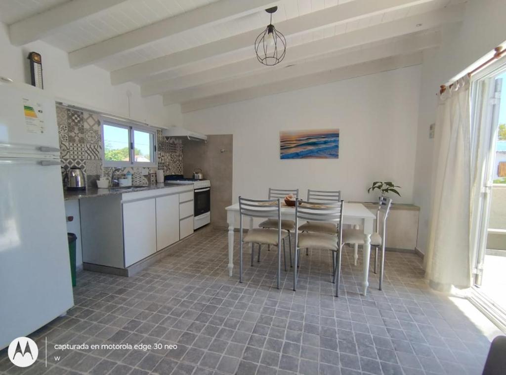 een keuken met een tafel en stoelen in een kamer bij Amanece en la playa 2 in Santa Teresita