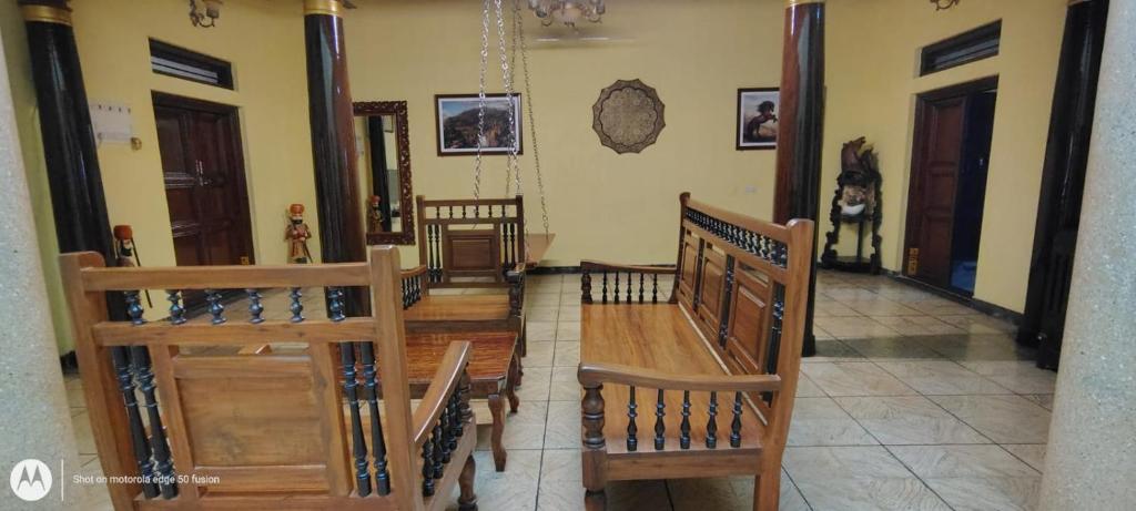 a group of wooden benches in a room at Elite Heritage Stay in Puducherry