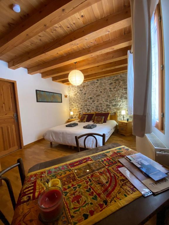 una camera da letto con un letto e un tavolo in una stanza di La Roche Meane a Villar-dʼArène
