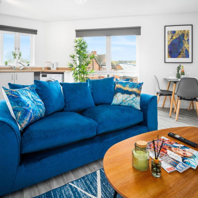 a blue couch in a living room with a table at Modern Two Bed Apartment - Sleeps 3 - Parking - Netflix 50C in Netherton