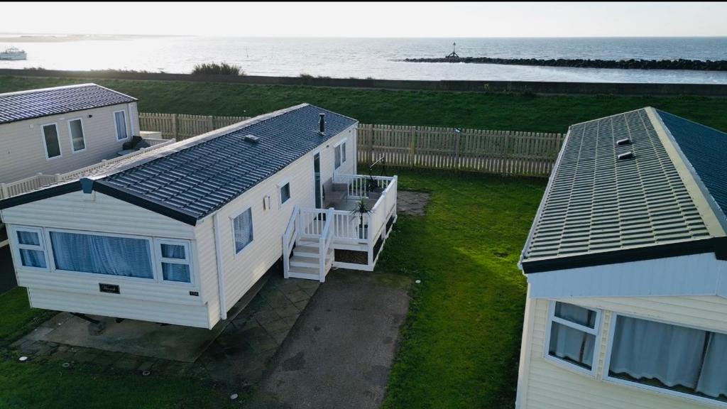 an aerial view of a house with the ocean behind it at Coastal Beachfront Caravan in Brightlingsea