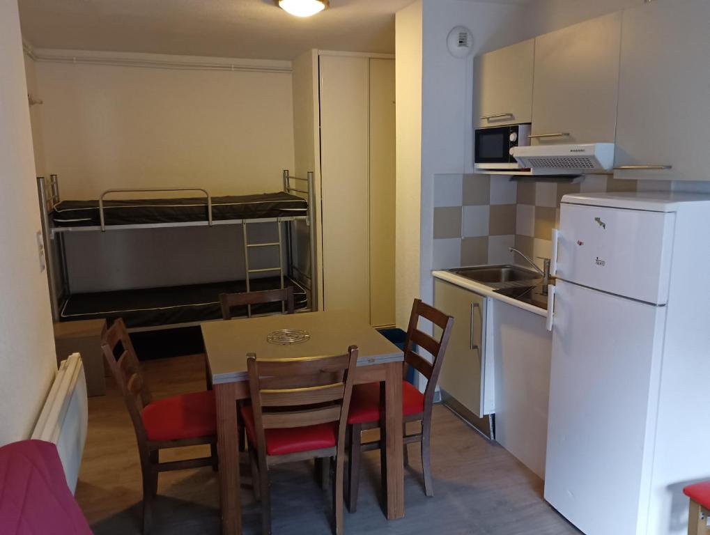 a small kitchen and dining room with a table and chairs at Chalets de L Isard D N35 2P6 in Les Angles