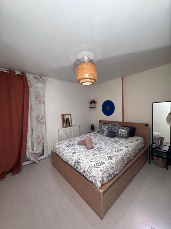 ein Schlafzimmer mit einem Bett und einer Decke in der Unterkunft Small 2 room cocoon in a luxury building in Lognes