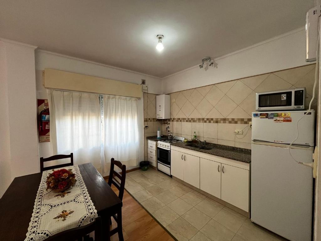 een keuken met een tafel en een witte koelkast bij Monoambiente COSTANERA NORTE in Colón