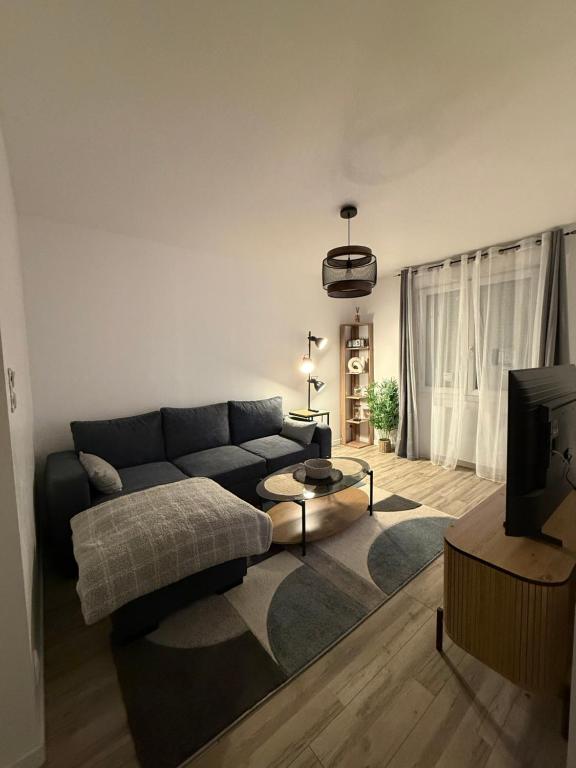 un soggiorno con un divano e una TV di CosyLoft a Châlette-sur-Loing