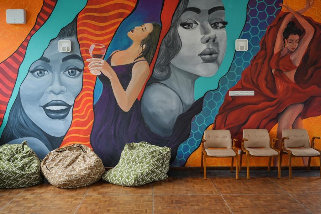 une fresque murale de femmes avec des chaises dans l'établissement Grand Ranketha Resort, à Kalutara