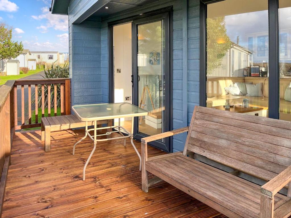 a patio with benches and a table on a deck at 19 Salcombe Retreat in Salcombe
