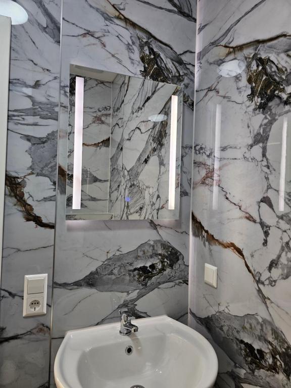 een badkamer met een wastafel en een spiegel bij Hotelikum in Heilbronn