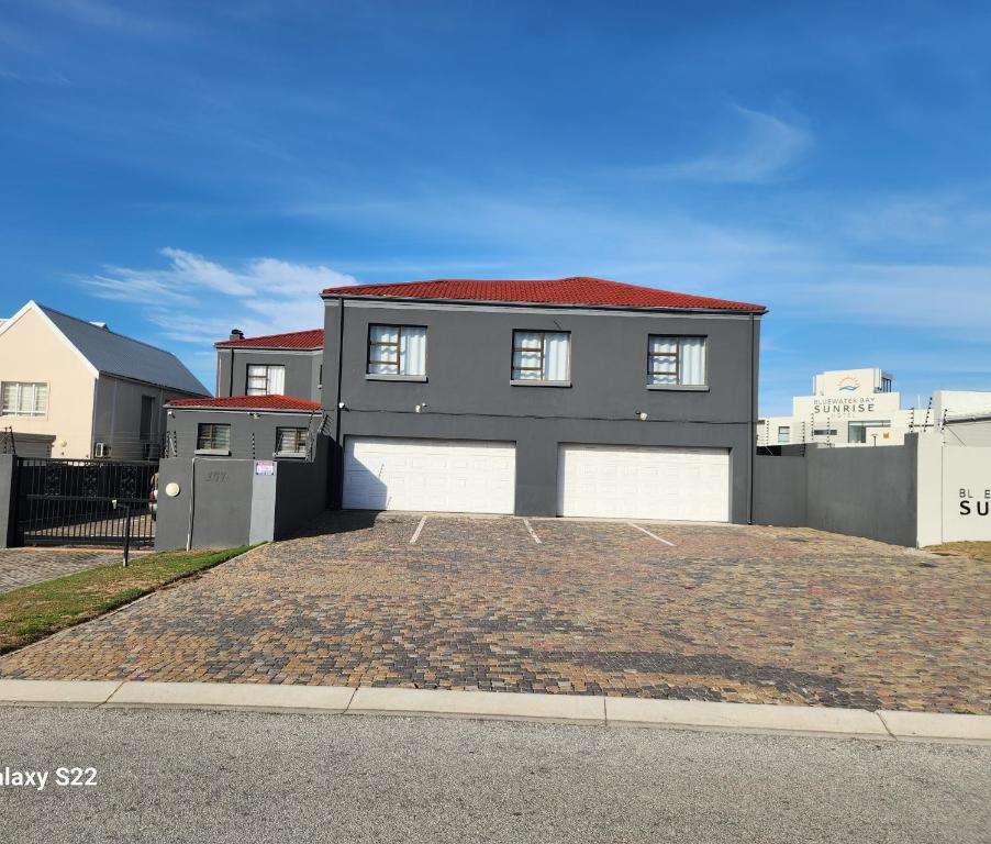 een huis met twee garagedeuren op een oprit bij Pado B & B in Gqeberha