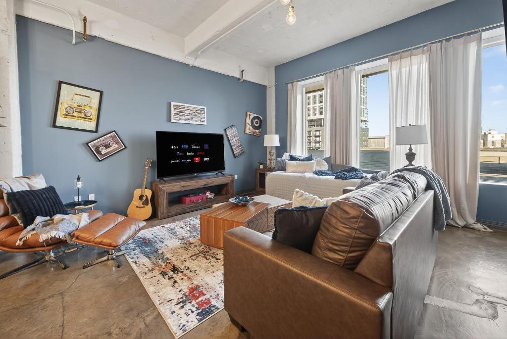 un soggiorno con un divano e una TV di Retro Music Flat, 2BR, FREE Valet, Gym, Pool, Downtown Dallas a Dallas