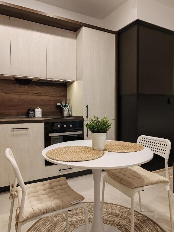 a kitchen with a white table and two chairs at SOHO apartments in Burgas