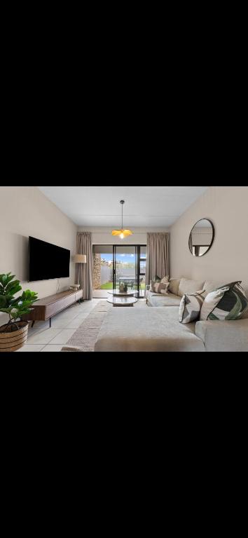 a large living room with a couch and a television at Prime location in upmarket security estate in Johannesburg