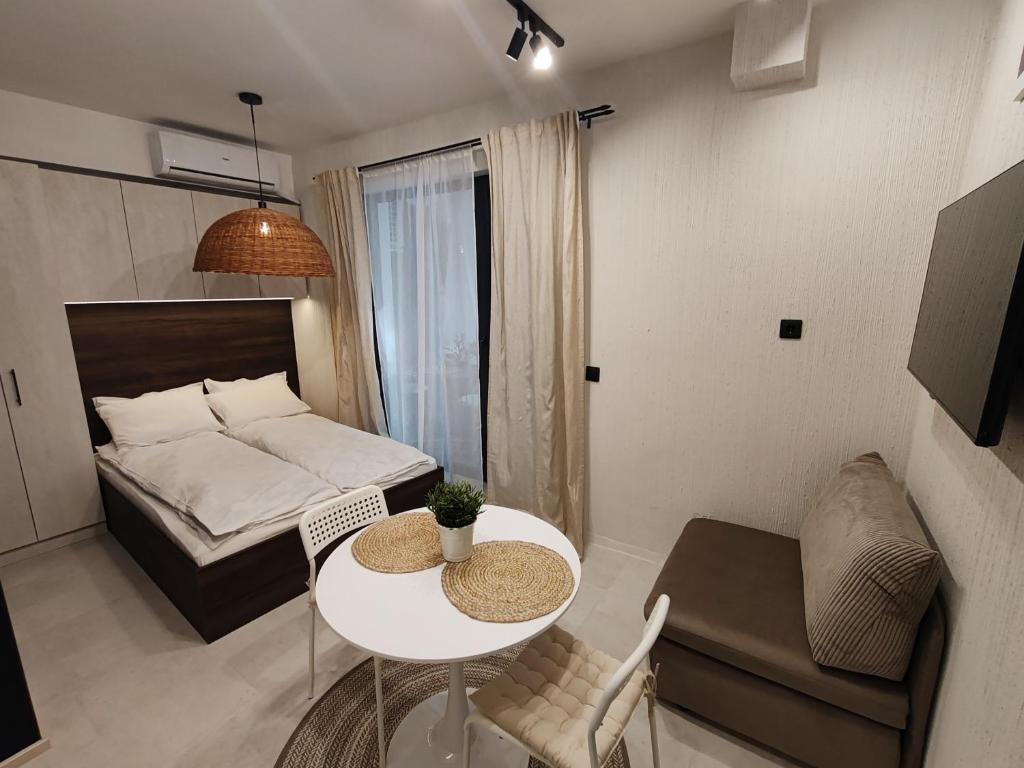 een kleine woonkamer met een bed en een tafel bij SOHO apartments in Boergas