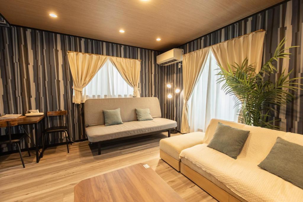 a living room with a couch and a table at 貸切新築ヴィラ l 最大9名 l 小田原城徒歩14分 l 無料P l 箱根板橋駅徒歩9分 l SENU VILLA Minamicho - Odawara in Odawara