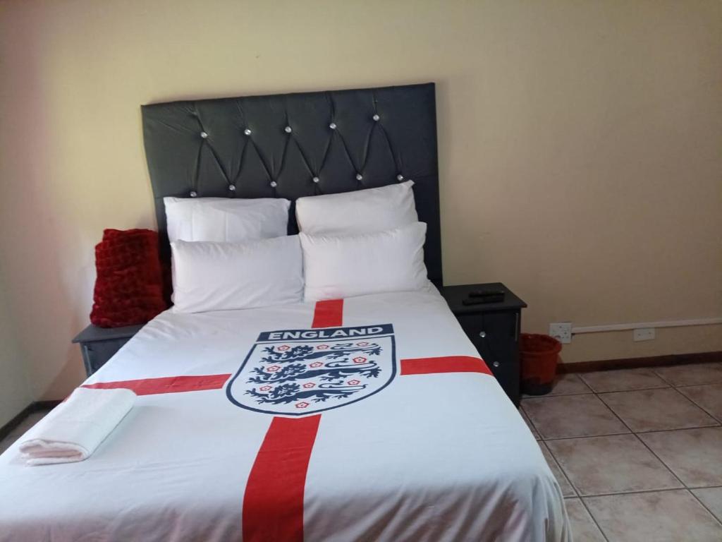 een slaapkamer met een bed met een rood-witte deken bij Shivon Vaal Guest House in Vanderbijlpark